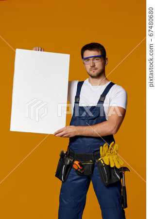 repairman worker holding empty blank board. 67480680