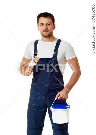 repairman in blue uniform holding paint brush and can with paint 67480700