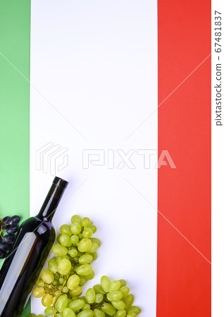 A bottle of wine, grapes, and the flag of Italy close-up. Country symbol backdrop. The concept of A bottle of wine, grapes, and the flag of Italy close-up. Country symbol backdrop. The concept of 67481837