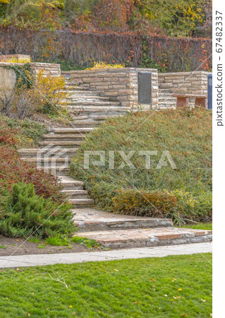 Outdoor landscaping with stairs bench and lawn 67482337