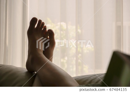 Woman relaxing on the sofa in the room Woman relaxing on the sofa in the room 67484135