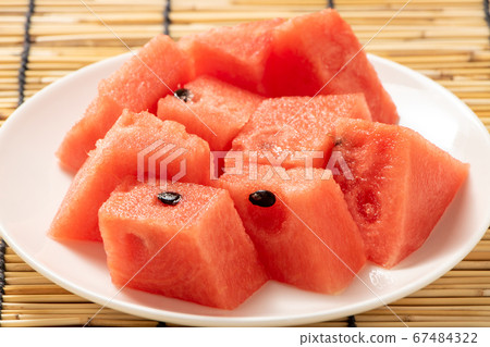 Watermelon cut into bite size. Summer image in the background blinds. Watermelon cut into bite size. Summer image in the background blinds. 67484322