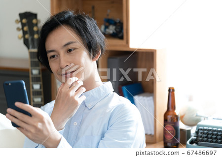 一名男子在智能手機上打可視電話[居住] 67486697
