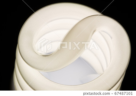 Fluorescent light bulb isolated on black background. Economical home lighting. Energy saving concept. Fluorescent light bulb isolated on black background. Economical home lighting. Energy saving concept. 67487101
