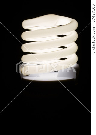 Fluorescent light bulb isolated on black background. Economical home lighting. Energy saving concept. Fluorescent light bulb isolated on black background. Economical home lighting. Energy saving concept. 67487109