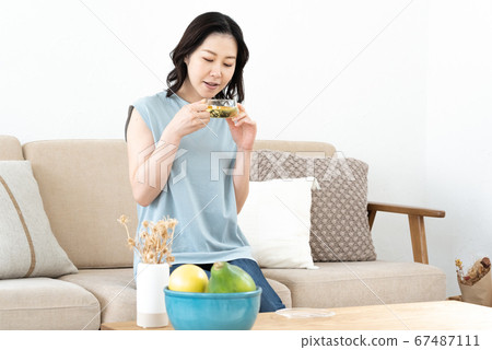 Middle woman drinking herbal tea on sofa Middle woman drinking herbal tea on sofa 67487111