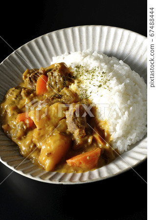 Curry rice with plenty of potatoes, carrots and beef tendon meat taken on a black background 67488444