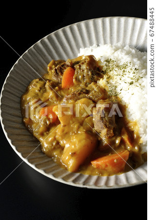 Curry rice with plenty of potatoes, carrots and beef tendon meat taken on a black background 67488445