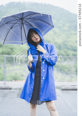 Woman wearing a raincoat in the rain 67489218
