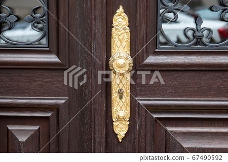 Luxurious door handle and lock on old wooden doors with glass Luxurious door handle and lock on old wooden doors with glass 67490592