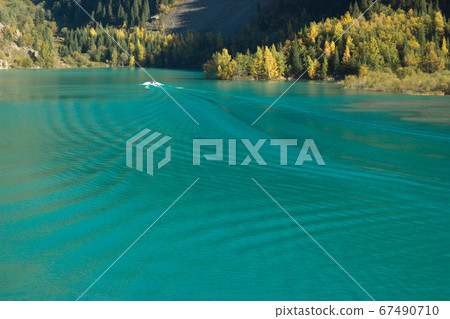 Little motorboat on the mountain lake. Little motorboat on the mountain lake. 67490710