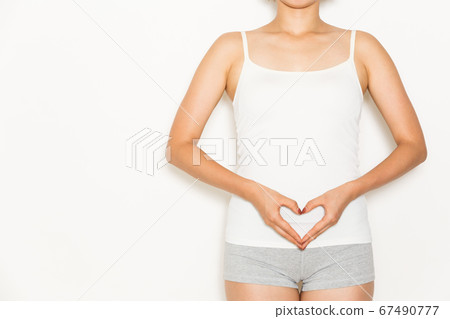 A woman making a heart on her stomach A woman making a heart on her stomach 67490777