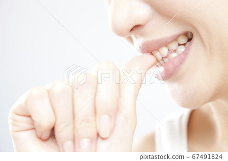 A woman biting a nail A woman biting a nail 67491824