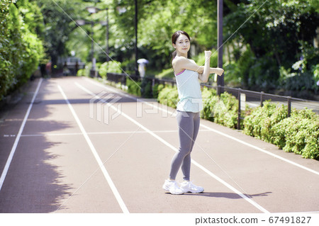 Young woman stretching in sportswear Young woman stretching in sportswear 67491827