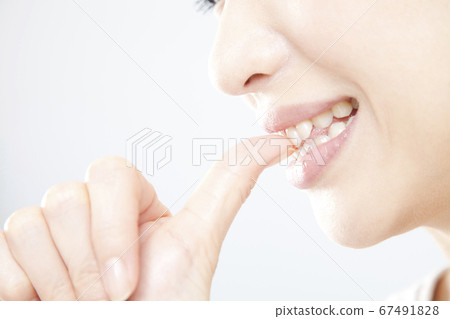 A woman biting a nail 67491828