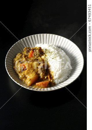 Curry and rice containing a lot of steamed potatoes, carrots and beef tendon (black background) 67493451