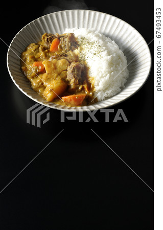Curry and rice containing a lot of steamed potatoes, carrots and beef tendon (black background) 67493453