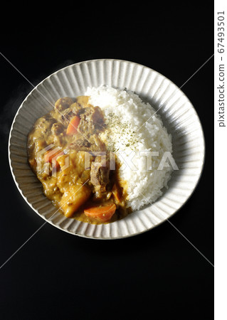 Curry and rice containing a lot of steamed potatoes, carrots and beef tendon (black background) Curry and rice containing a lot of steamed potatoes, carrots and beef tendon (black background) 67493501