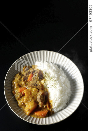 Curry and rice containing a lot of steamed potatoes, carrots and beef tendon (black background) 67493502