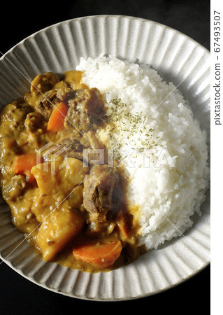 Curry and rice containing a lot of steamed potatoes, carrots and beef tendon (black background) 67493507