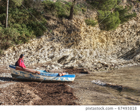 Hiker woman dreaming about sailing, boat on bank Hiker woman dreaming about sailing, boat on bank 67493818
