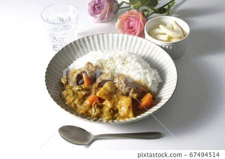 Behind the hot beef tenderloin curry with lots of vegetables, there are chilled gyoza and roses. Behind the hot beef tenderloin curry with lots of vegetables, there are chilled gyoza and roses. 67494514