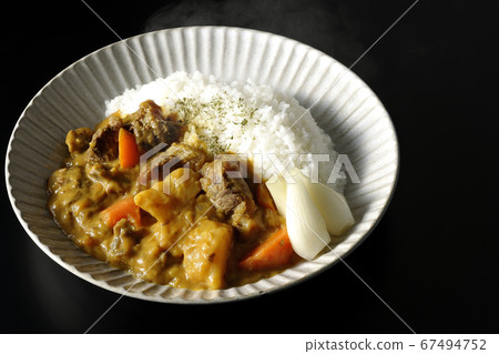 Hot curry rice with plenty of potatoes, carrots and beef tendon meat taken on a black background Hot curry rice with plenty of potatoes, carrots and beef tendon meat taken on a black background 67494752