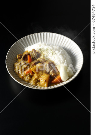 熱咖哩飯,用大量的土豆,胡蘿蔔和牛筋肉在黑色背景上採取 熱咖哩飯,用大量的土豆,胡蘿蔔和牛筋肉在黑色背景上採取 67494754