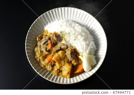 Hot curry rice with plenty of carrots, potatoes, and beef tendon meat shot on a black background (overview) 67494771