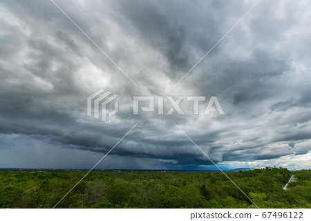Storm clouds with rain over meadow with forest Storm clouds with rain over meadow with forest 67496122