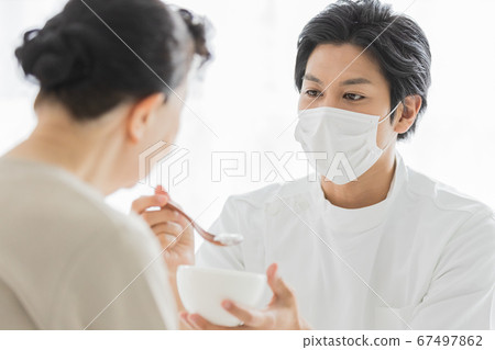 護理人員戴口罩幫助進餐 67497862