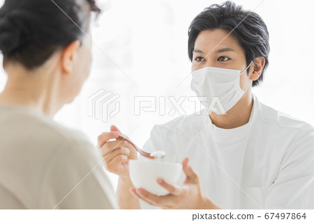 護理人員戴口罩幫助進餐 護理人員戴口罩幫助進餐 67497864
