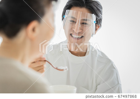 戴著口罩的護理人員可幫助用餐 戴著口罩的護理人員可幫助用餐 67497868