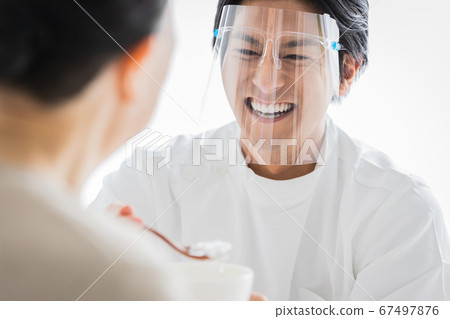 Nursing staff wearing face shields to help with meals 67497876