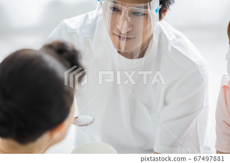 Nursing staff wearing face shields to help with meals 67497881