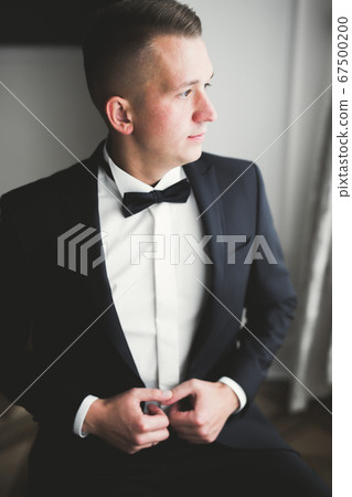 Beautiful man, groom posing and preparing for wedding 67500200