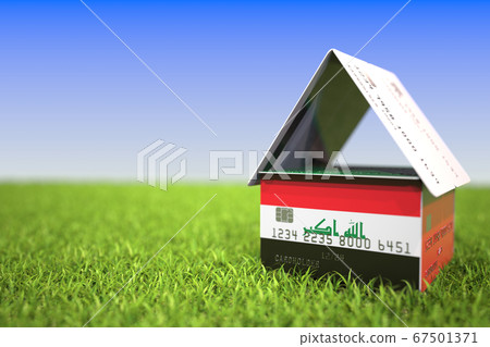 Flag of Iraq on plastic bank card house in the grass. Mortgage related 3D rendering 67501371
