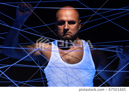 Photo of bald man tangled in white threads 67501885