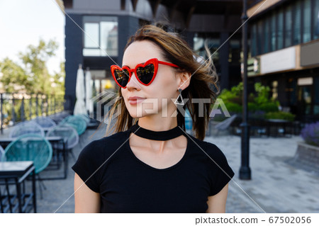 Fashion portrait of woman in black t-shirt and red skirt walking Fashion portrait of woman in black t-shirt and red skirt walking 67502056