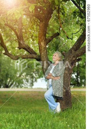 Happy senior beautiful woman posing in park Happy senior beautiful woman posing in park 67502960