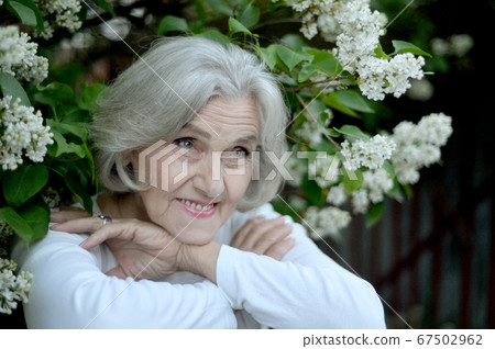 Happy senior beautiful woman with lilacs in spring park Happy senior beautiful woman with lilacs in spring park 67502962