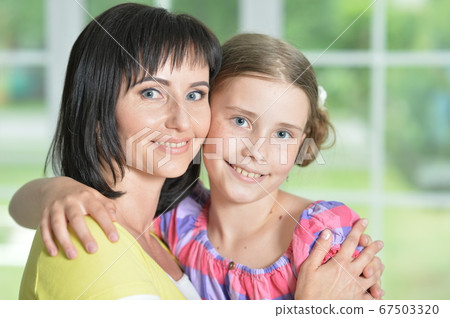 Portrait of a charming little girl hugging with mom at home 67503320