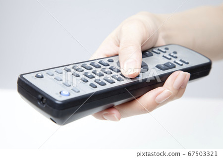 Hand holding remote control 67503321