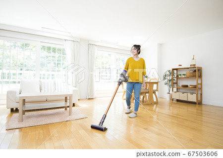 Young woman cleaning the living room 67503606