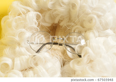 eyeglasses on judge wig on yellow background. eyeglasses on judge wig on yellow background. 67503948