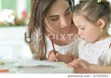Cute girl with mother drawing at the table Cute girl with mother drawing at the table 67503952