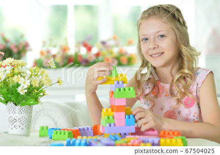 Little girl playing with colorful plastic blocks Little girl playing with colorful plastic blocks 67504025