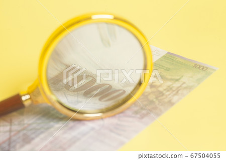 Swiss 1000 Franc banknotes under magnifying glass Swiss 1000 Franc banknotes under magnifying glass 67504055