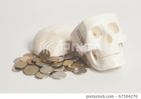 Coins and skulls head 67504276