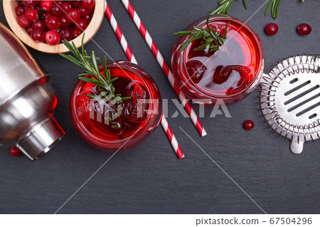 Two glasses of cranberry cocktail with rosemary Two glasses of cranberry cocktail with rosemary 67504296